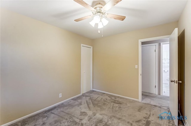 carpeted spare room featuring ceiling fan