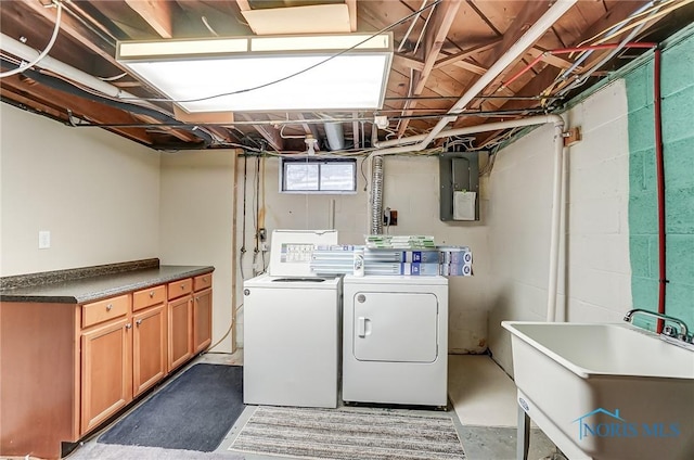 washroom featuring sink, washing machine and dryer, cabinets, and electric panel