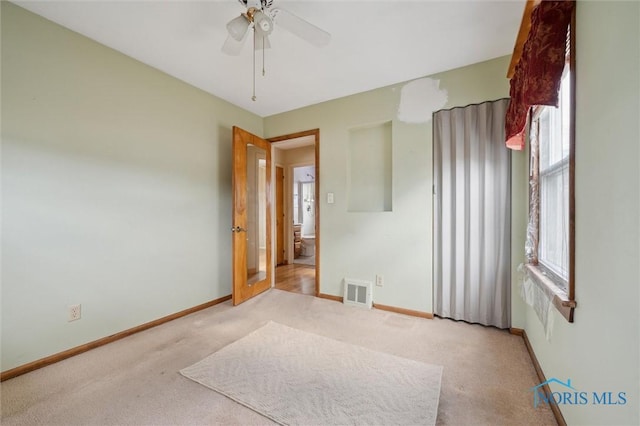 carpeted spare room featuring ceiling fan