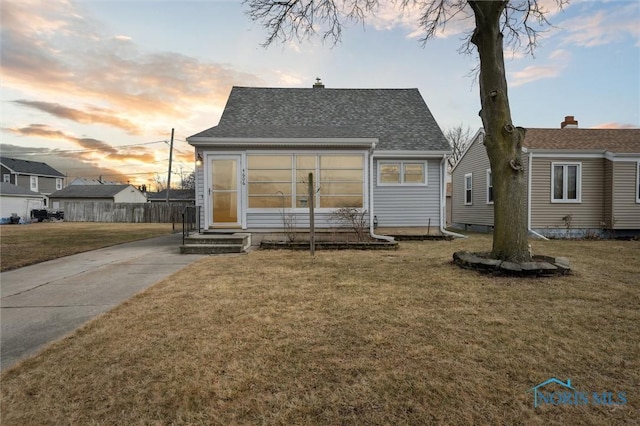 back house at dusk with a yard