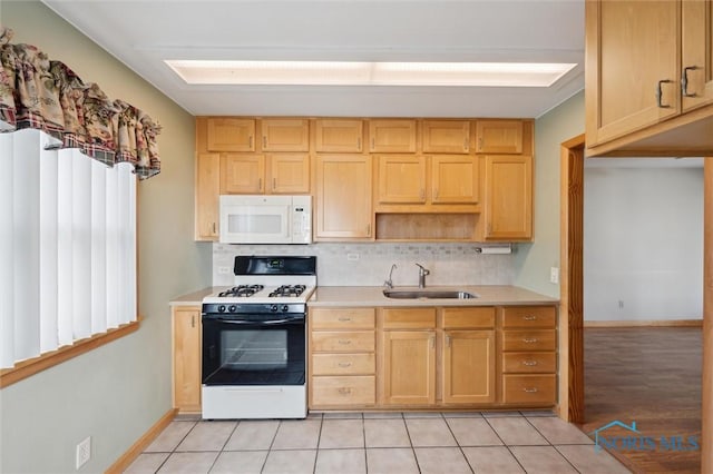 kitchen with tasteful backsplash, sink, light tile patterned floors, and white appliances