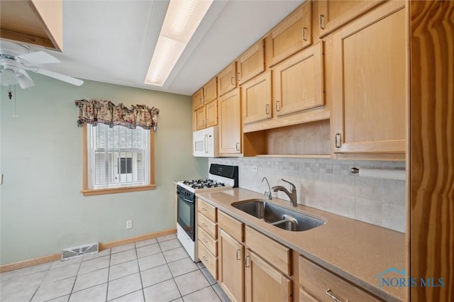 kitchen featuring sink, white appliances, light tile patterned floors, decorative backsplash, and light brown cabinets