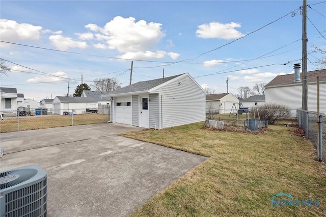 view of outbuilding with a yard, a garage, and central AC unit