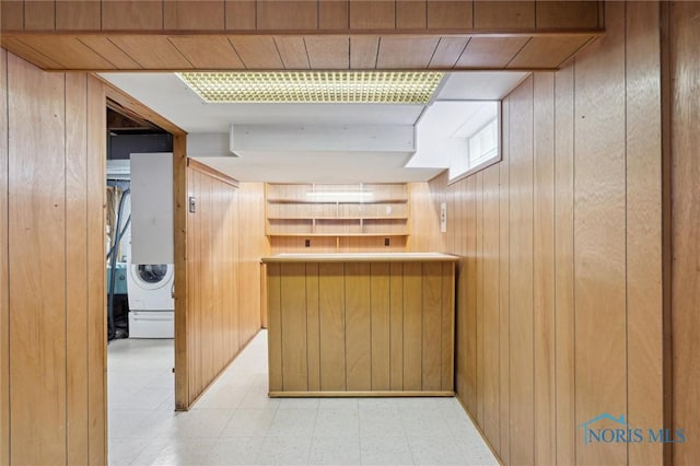 kitchen featuring washer / dryer and wood walls