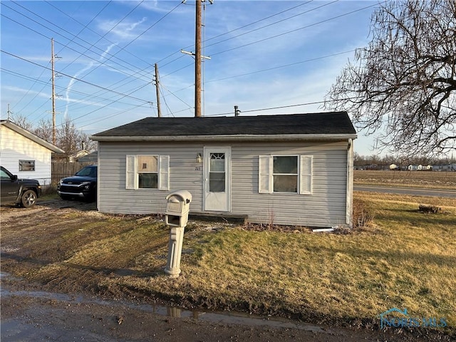 bungalow-style home featuring fence and a front lawn