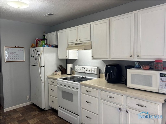 kitchen with under cabinet range hood, white appliances, visible vents, white cabinets, and light countertops