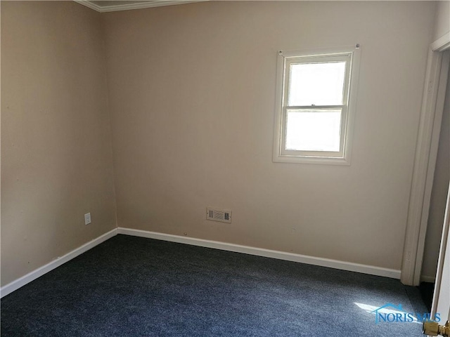 spare room with dark carpet