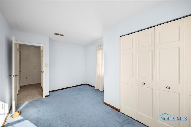 unfurnished bedroom with baseboards, a closet, visible vents, and light colored carpet