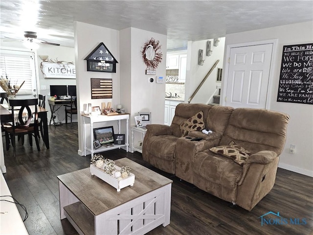 living room featuring dark hardwood / wood-style flooring and ceiling fan