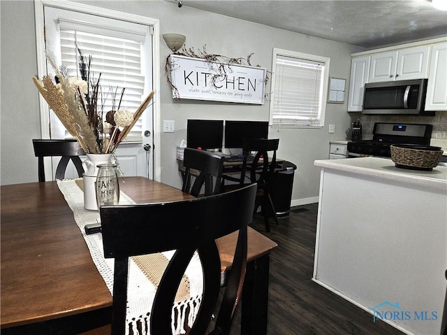 dining space featuring dark wood-type flooring and a healthy amount of sunlight