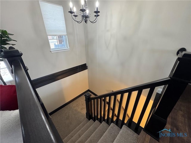 stairs with a notable chandelier and carpet