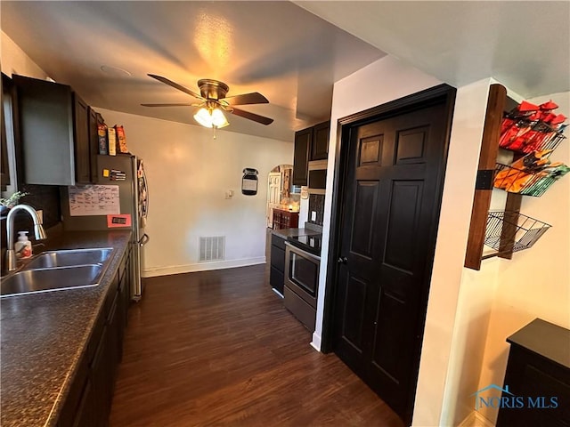 kitchen with stainless steel electric stove, sink, decorative backsplash, ceiling fan, and dark wood-type flooring