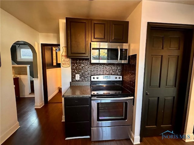 kitchen featuring tasteful backsplash, appliances with stainless steel finishes, dark hardwood / wood-style floors, and dark brown cabinets