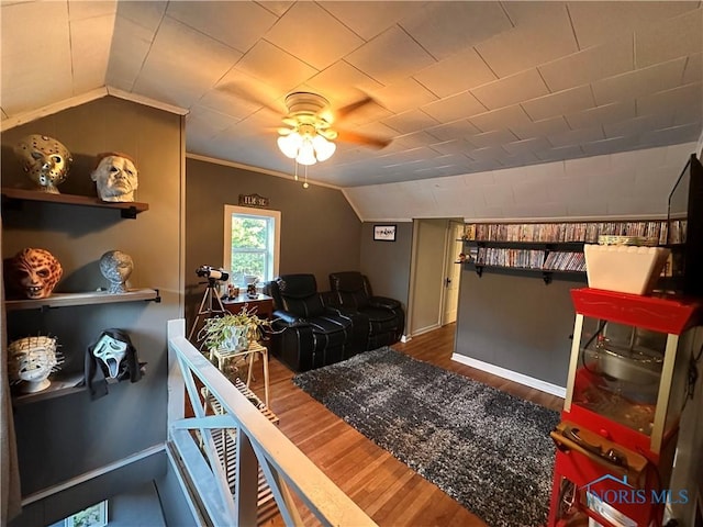 living room with ceiling fan, lofted ceiling, wood-type flooring, and ornamental molding