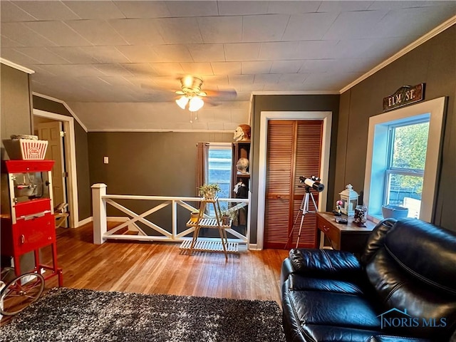 living room with hardwood / wood-style flooring, vaulted ceiling, and ornamental molding