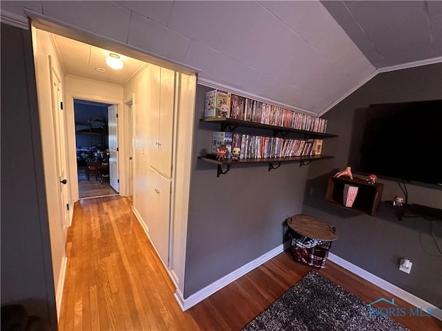 hallway with lofted ceiling and light wood-type flooring