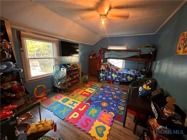 bedroom featuring lofted ceiling, hardwood / wood-style floors, crown molding, and ceiling fan