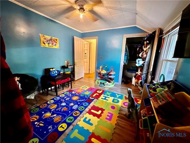 playroom featuring hardwood / wood-style flooring, ceiling fan, ornamental molding, and vaulted ceiling