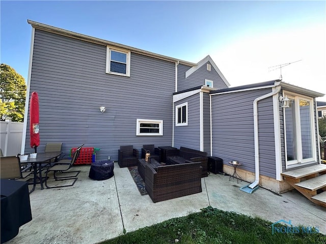 back of property featuring an outdoor living space and a patio