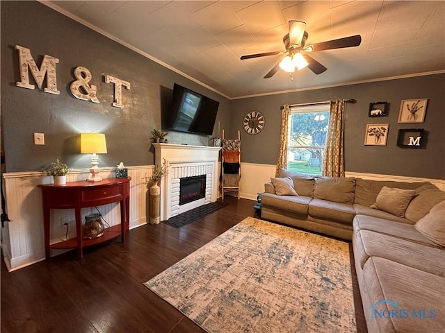 living room with dark wood-type flooring, crown molding, and a brick fireplace