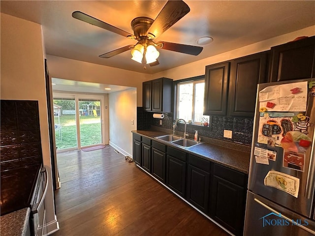 kitchen with sink, dark wood-type flooring, stainless steel fridge, ceiling fan, and tasteful backsplash