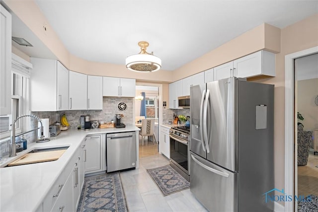 kitchen featuring white cabinetry, sink, backsplash, and appliances with stainless steel finishes