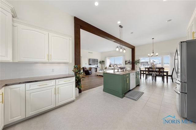 kitchen featuring stainless steel refrigerator, white cabinetry, white dishwasher, decorative light fixtures, and a chandelier