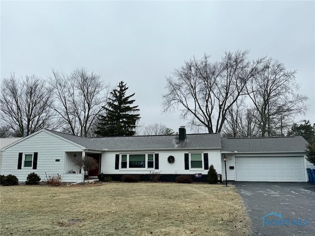 single story home with a garage and a front lawn