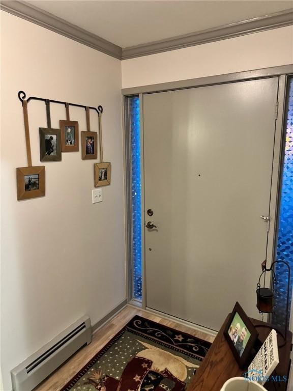 entrance foyer featuring hardwood / wood-style floors, ornamental molding, and baseboard heating