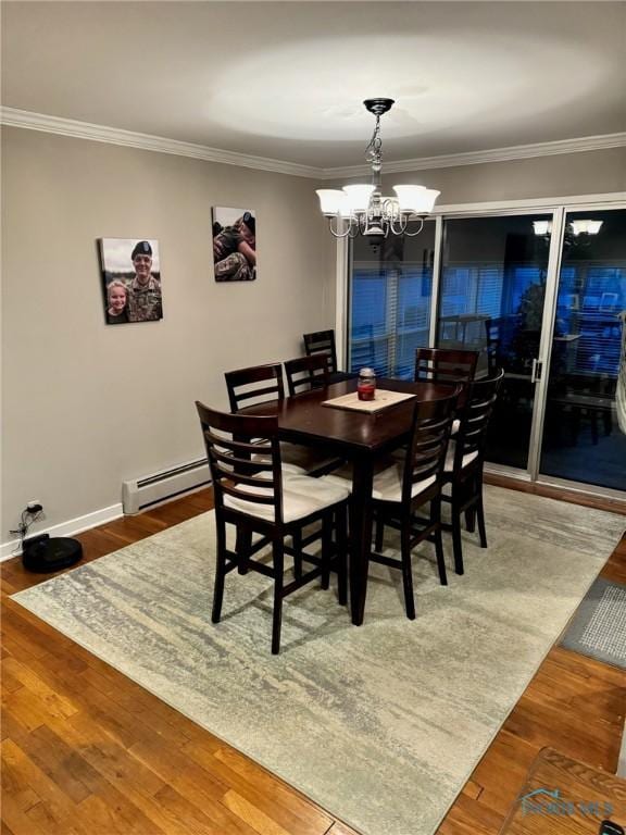 dining space featuring an inviting chandelier, hardwood / wood-style floors, ornamental molding, and a baseboard heating unit