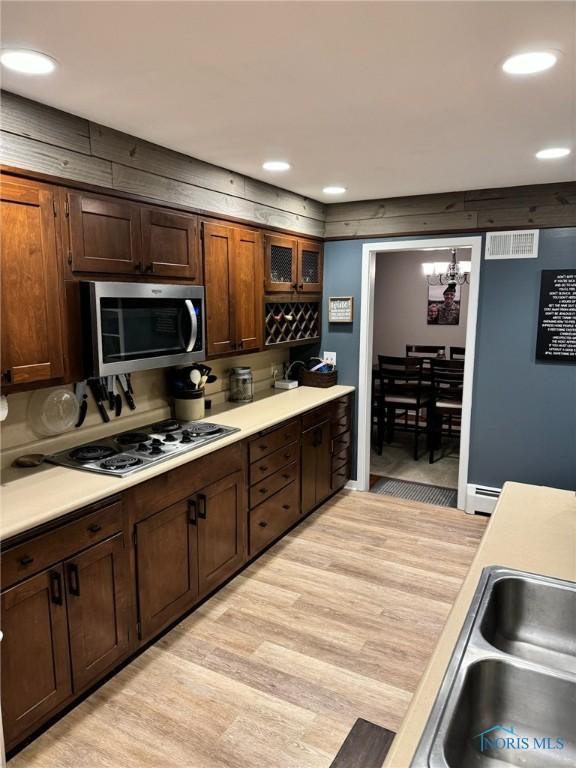 kitchen with gas stovetop, sink, and light hardwood / wood-style flooring