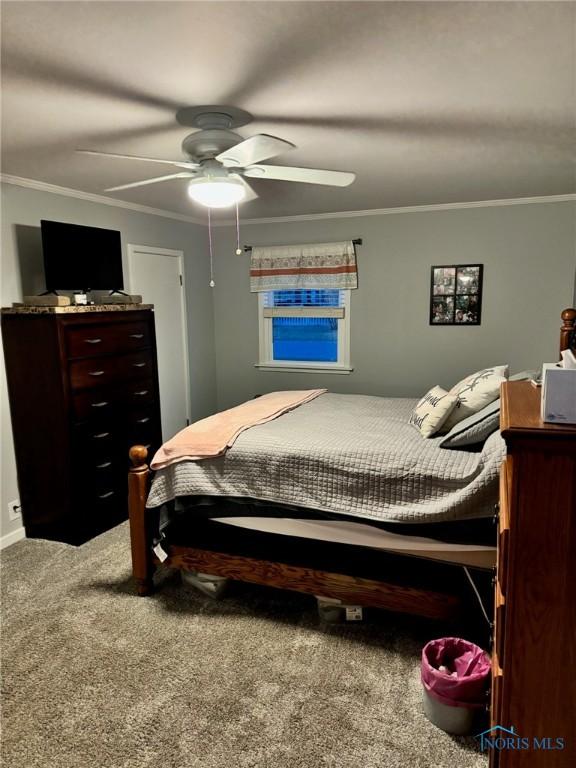 bedroom featuring ceiling fan, ornamental molding, and carpet flooring