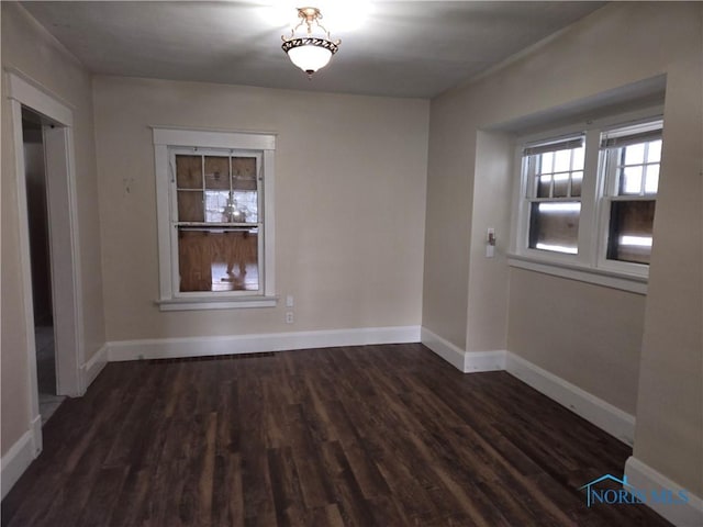 spare room with dark wood-type flooring