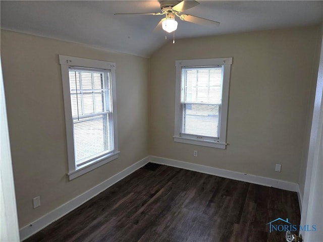 empty room featuring vaulted ceiling, dark hardwood / wood-style floors, and ceiling fan