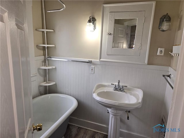 bathroom featuring a tub to relax in and hardwood / wood-style floors