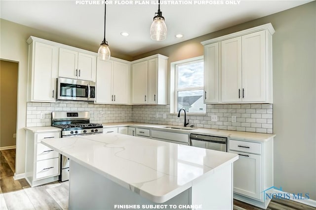 kitchen featuring decorative light fixtures, white cabinetry, sink, a center island, and stainless steel appliances