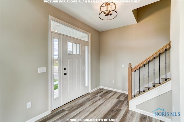 foyer entrance featuring wood-type flooring and an inviting chandelier