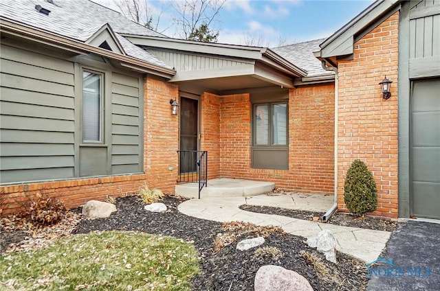 32 Abbey Rd, Perrysburg, OH 43551 - property entrance featuring brick siding, an attached garage, and roof with shingles