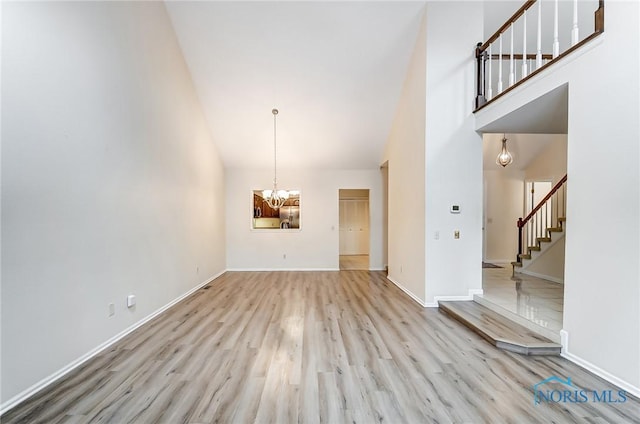 interior space with high vaulted ceiling, light hardwood / wood-style floors, and a chandelier