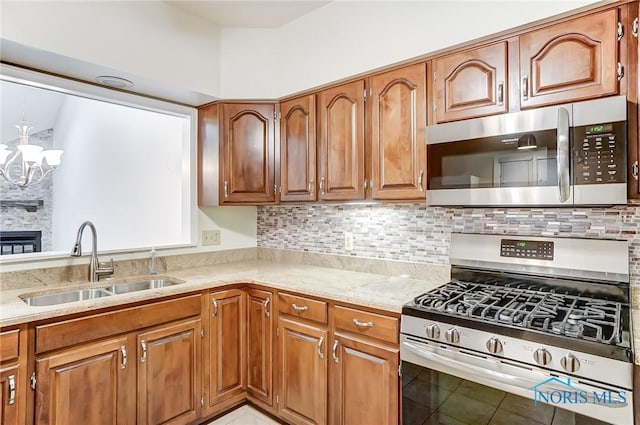 kitchen featuring tasteful backsplash, sink, stainless steel appliances, and a chandelier