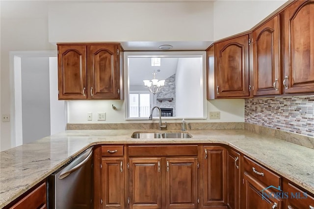 kitchen featuring light stone counters, sink, decorative backsplash, and stainless steel dishwasher