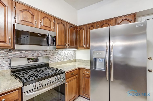 kitchen featuring appliances with stainless steel finishes, decorative backsplash, and light tile patterned floors