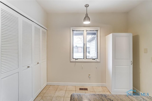 interior space featuring light tile patterned floors and a closet