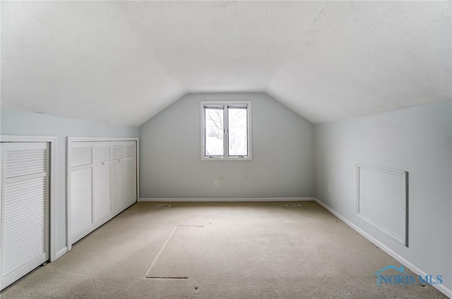 bonus room featuring light colored carpet and vaulted ceiling