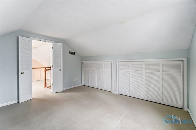 bonus room with light colored carpet and vaulted ceiling