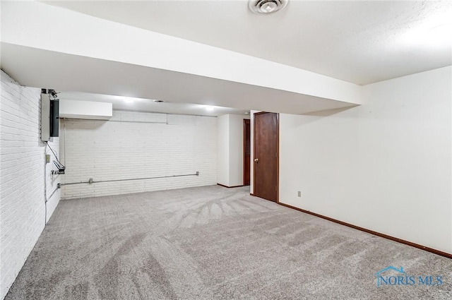 basement featuring brick wall and carpet floors