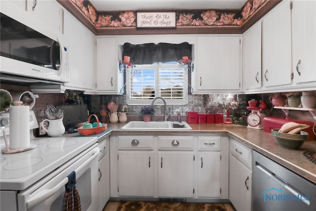 kitchen featuring tasteful backsplash, sink, white appliances, and white cabinets