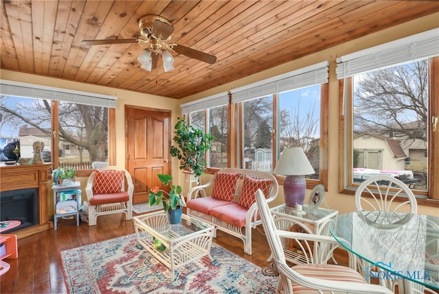 sunroom featuring ceiling fan, plenty of natural light, and wood ceiling