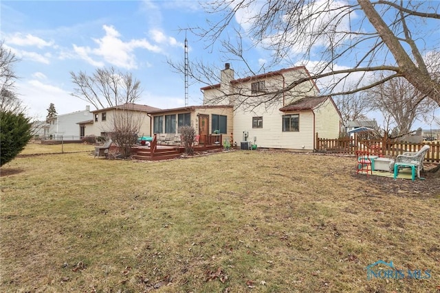 back of house featuring a lawn, a sunroom, central air condition unit, and a deck