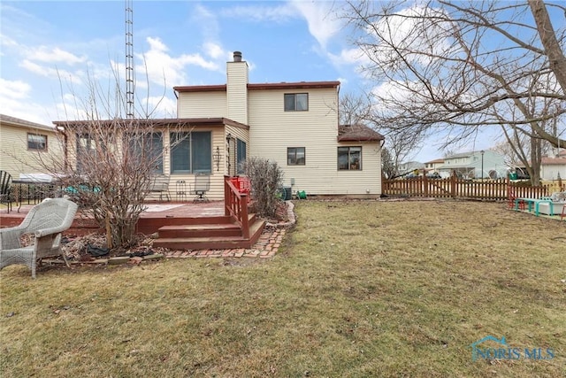 rear view of house with a yard and a deck